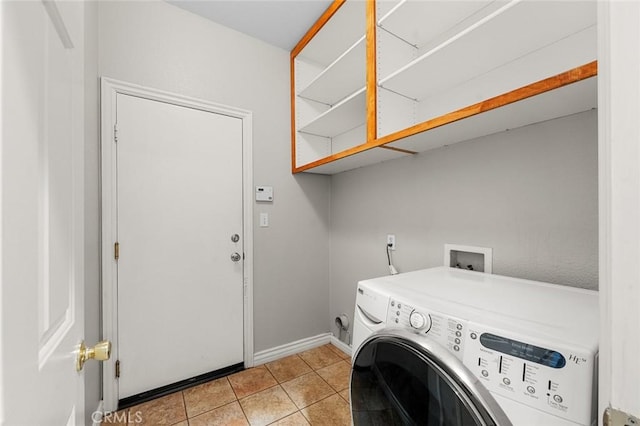 laundry area with washer / dryer, laundry area, light tile patterned flooring, and baseboards