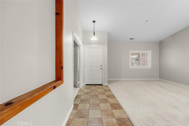 interior space featuring visible vents, light carpet, and baseboards