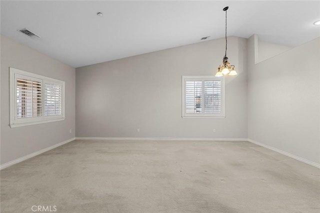 spare room featuring light carpet, baseboards, visible vents, lofted ceiling, and an inviting chandelier