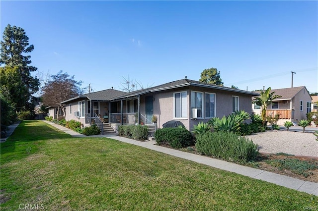 ranch-style house featuring cooling unit, covered porch, and a front lawn