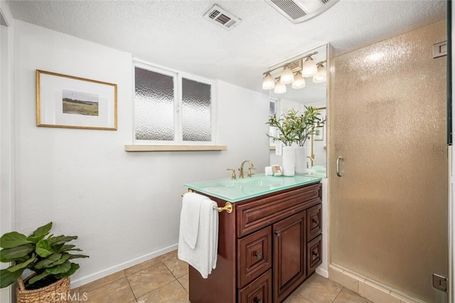 bathroom featuring a shower with door, vanity, tile patterned floors, and a textured ceiling