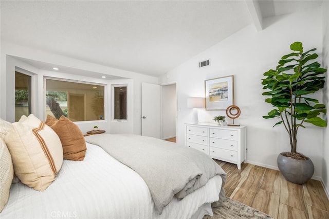 bedroom with lofted ceiling and light wood-type flooring