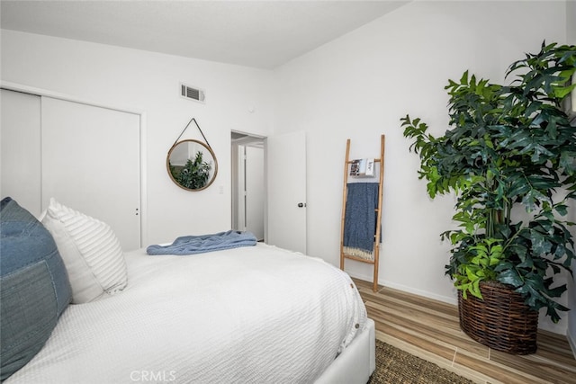 bedroom featuring lofted ceiling, hardwood / wood-style flooring, and a closet