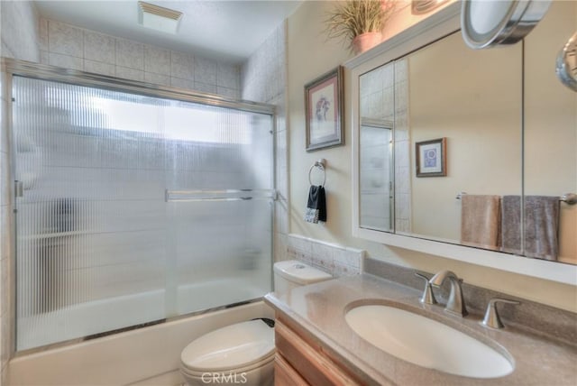 full bathroom featuring vanity, toilet, and combined bath / shower with glass door