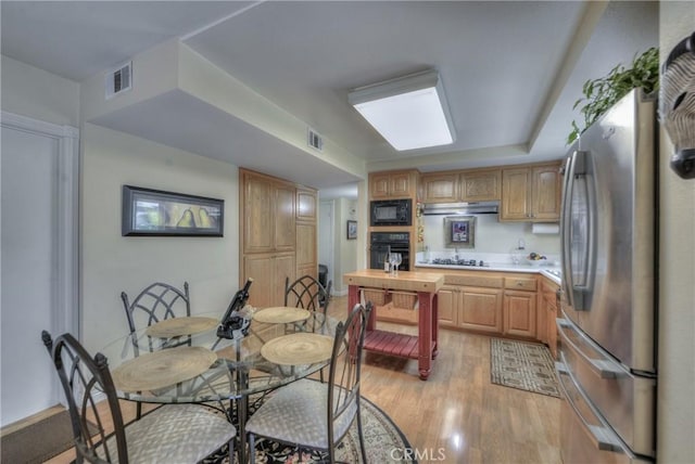 kitchen featuring black appliances and light hardwood / wood-style floors