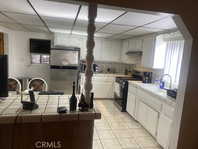 kitchen featuring white cabinetry, appliances with stainless steel finishes, sink, and tile countertops