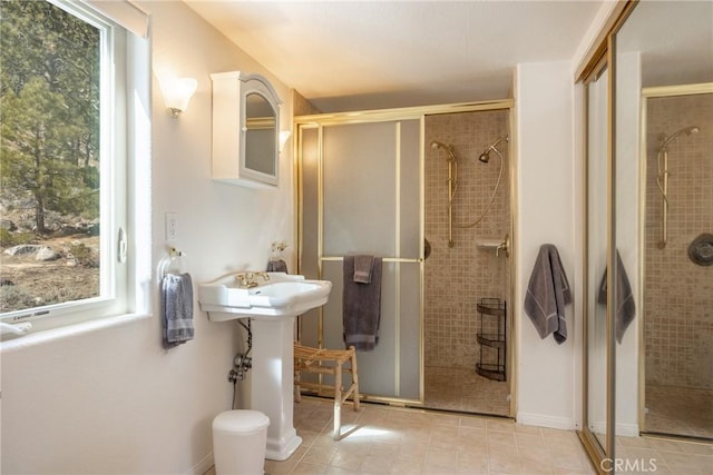 full bathroom with tile patterned floors, a shower stall, and a sink