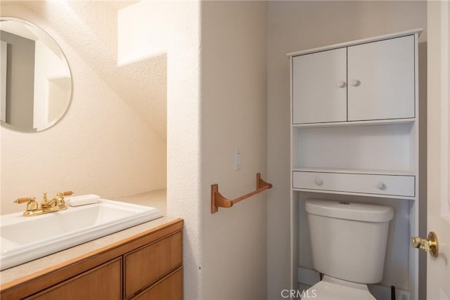 half bathroom featuring vanity and toilet