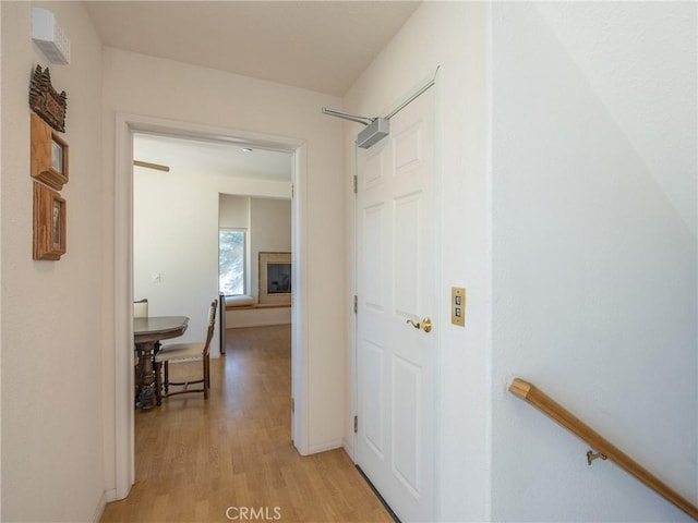 corridor with baseboards and light wood-style floors