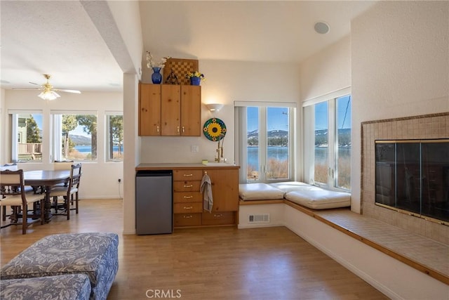 interior space featuring a ceiling fan, light wood-style floors, fridge, and plenty of natural light