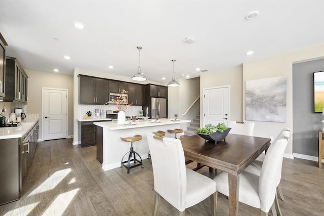 dining area with baseboards, stairway, wood finished floors, and recessed lighting