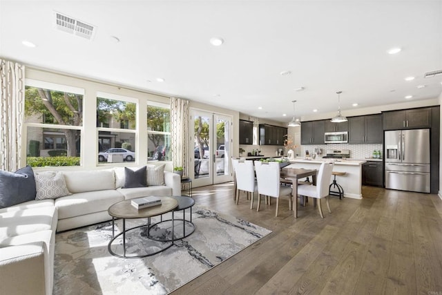 living room with visible vents, hardwood / wood-style floors, and recessed lighting