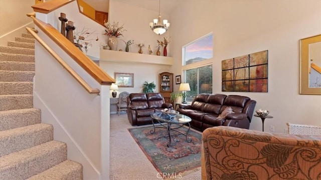 carpeted living room featuring a towering ceiling and a chandelier