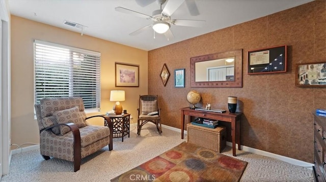 sitting room featuring light colored carpet and ceiling fan