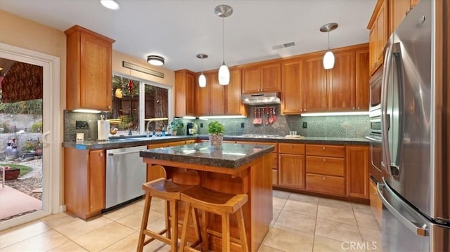 kitchen featuring pendant lighting, a breakfast bar, stainless steel appliances, and a center island