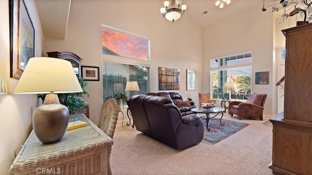 living room featuring an inviting chandelier, a towering ceiling, and carpet