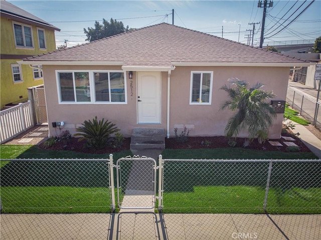 bungalow-style home with a shingled roof, a fenced front yard, a gate, and stucco siding