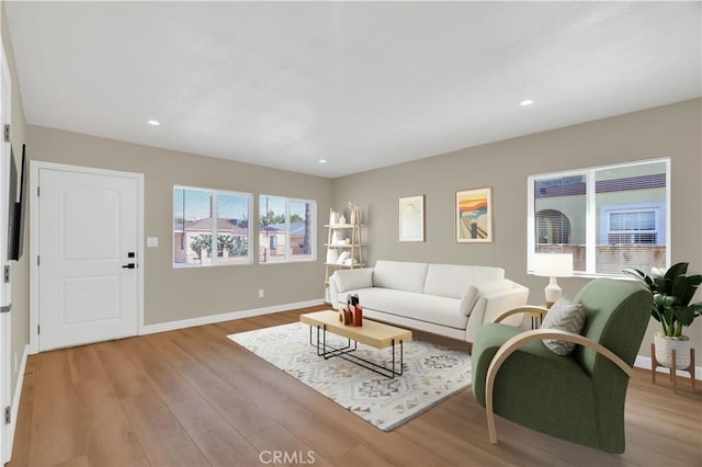 living area with light wood finished floors, baseboards, and recessed lighting