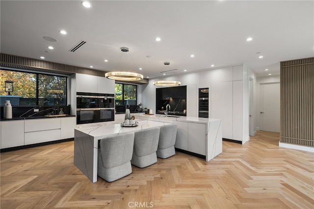 kitchen with pendant lighting, white cabinets, and a spacious island