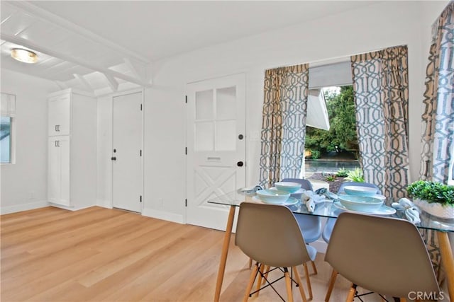 dining area featuring wood-type flooring and beam ceiling