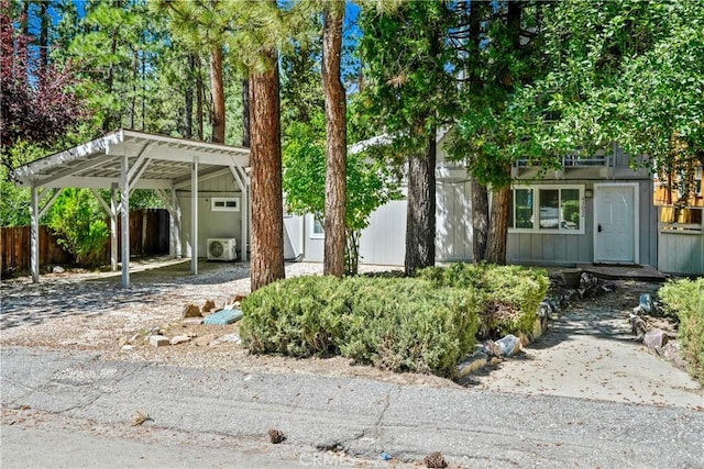 view of front facade with a carport, ac unit, and fence