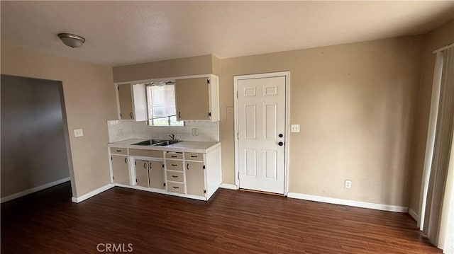 kitchen featuring dark hardwood / wood-style flooring, sink, decorative backsplash, and white cabinets