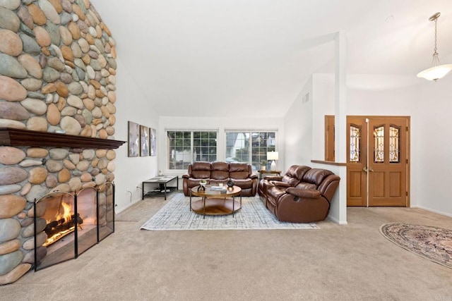 living room with light carpet, a stone fireplace, and high vaulted ceiling