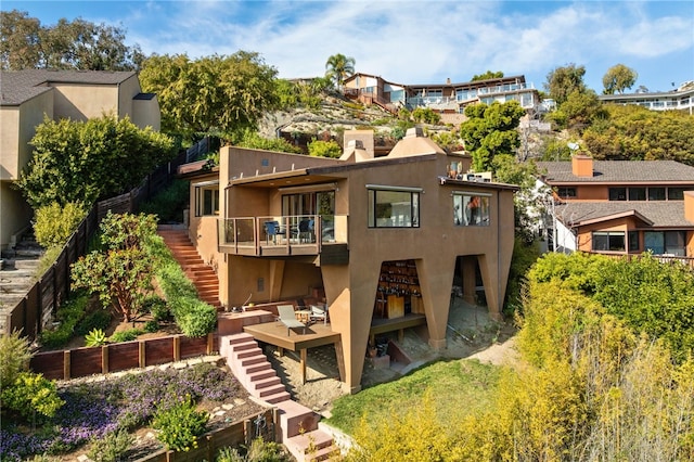 rear view of property featuring stairway, a patio, and stucco siding