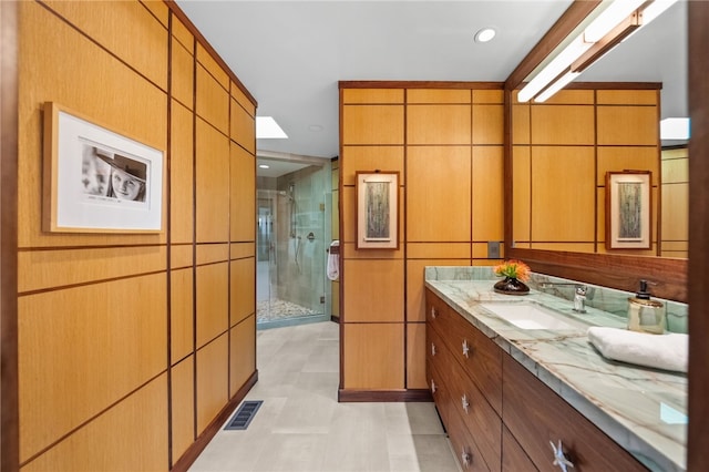 bathroom with a shower stall, visible vents, tile walls, and vanity