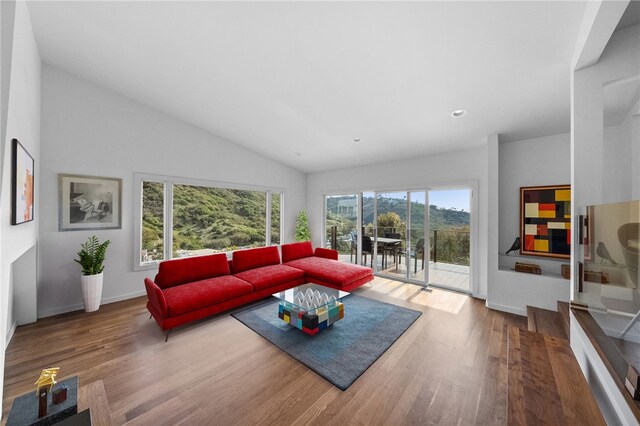 living room featuring baseboards, vaulted ceiling, wood finished floors, and recessed lighting