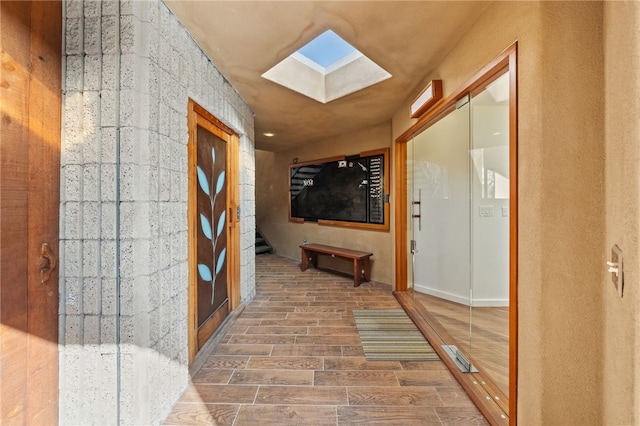 hallway featuring a skylight and wood tiled floor