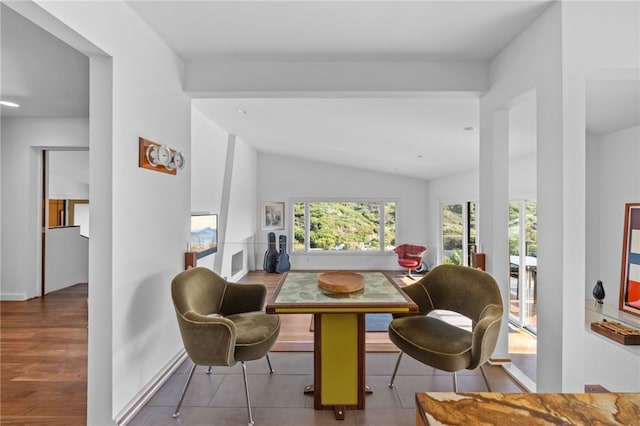 living area with vaulted ceiling, light wood finished floors, and baseboards