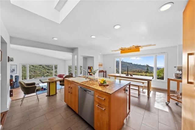 kitchen with a center island with sink, brown cabinetry, dishwasher, modern cabinets, and a sink