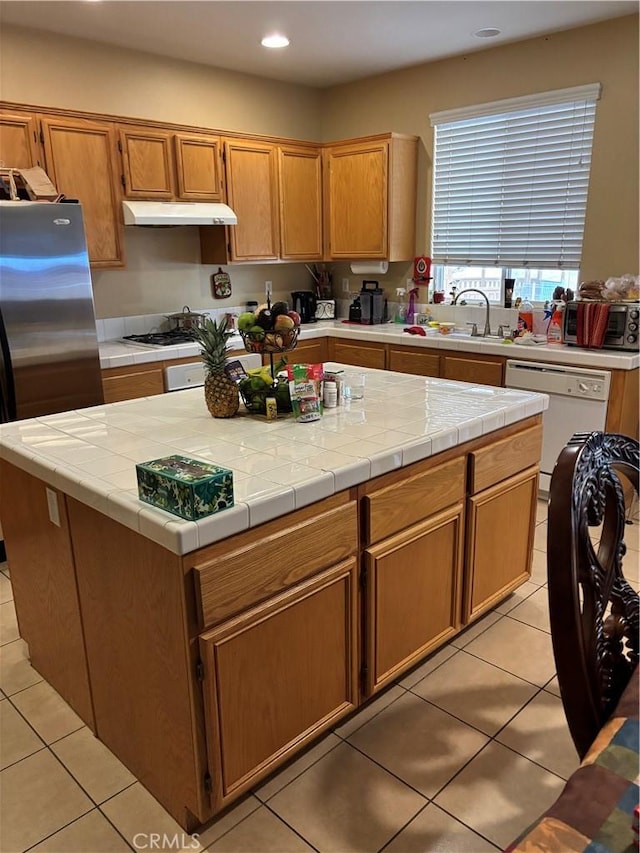 13023 Tehachapi St, Hesperia, CA 92344 - kitchen with stainless steel refrigerator, a center island, white dishwasher, light tile patterned flooring, and tile countertops