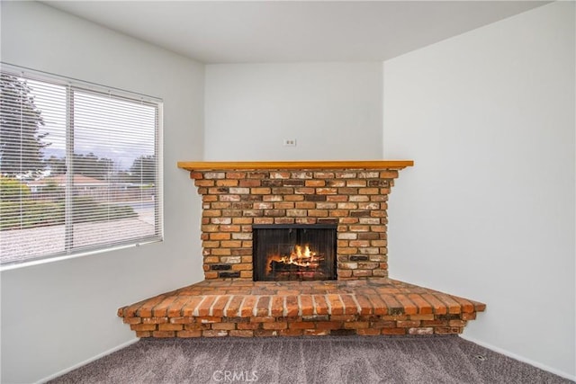 room details featuring a brick fireplace and carpet