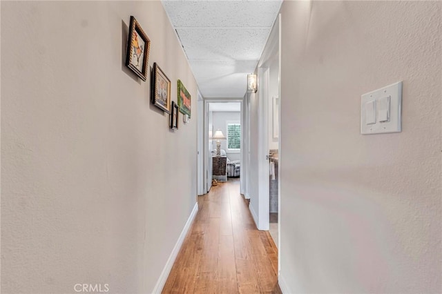 hallway featuring baseboards and light wood-type flooring