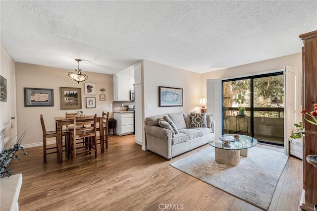 28010 Tiffany Ln Unit 309, Canyon Country, CA 91387 - living area featuring a textured ceiling, light wood-style floors, and baseboards
