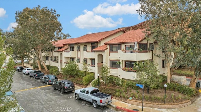 view of building exterior with a residential view and uncovered parking