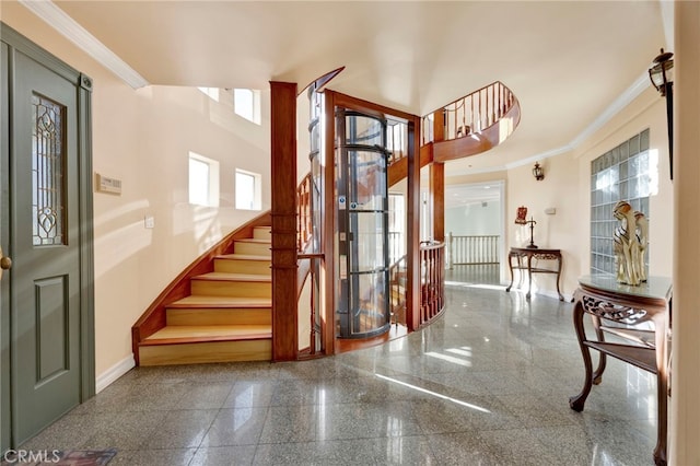 entrance foyer with ornamental molding, a healthy amount of sunlight, and a high ceiling