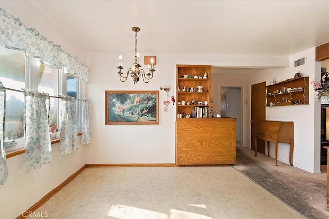 unfurnished dining area with carpet flooring and an inviting chandelier