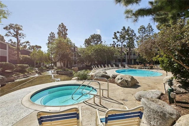 view of pool featuring a patio and a community hot tub