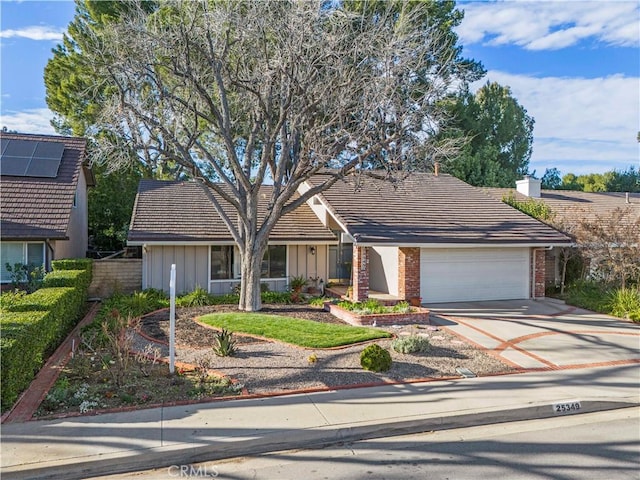 ranch-style home featuring brick siding, concrete driveway, an attached garage, board and batten siding, and a tiled roof