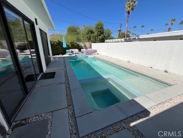 view of pool featuring an in ground hot tub