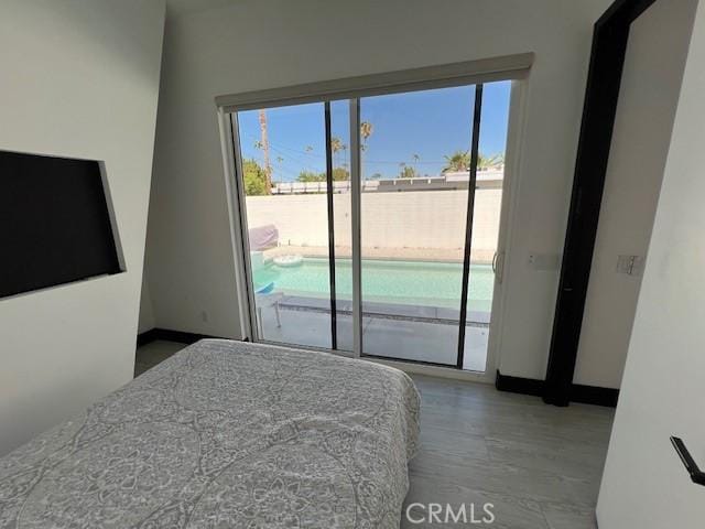 bedroom with access to exterior and light hardwood / wood-style flooring