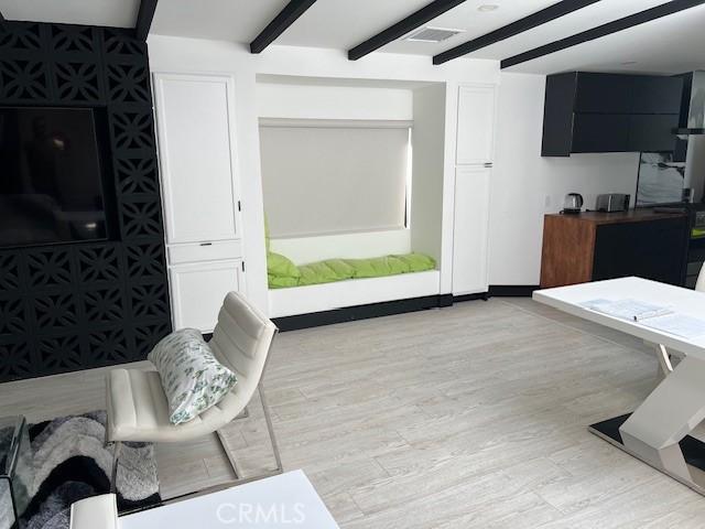 living room featuring light hardwood / wood-style flooring and beamed ceiling