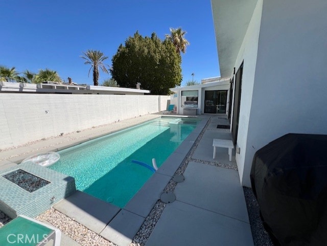 view of pool with a grill and a patio