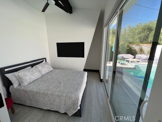 bedroom featuring ceiling fan, dark hardwood / wood-style floors, and beam ceiling