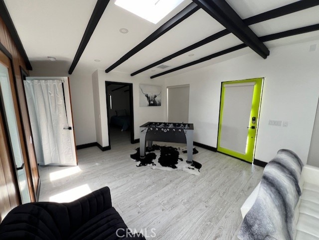 workout area with light wood-type flooring and a skylight