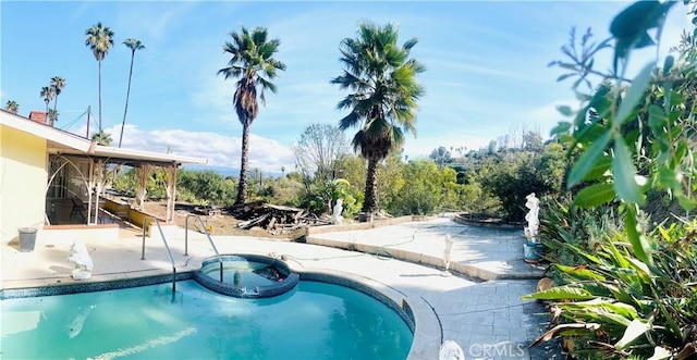 view of swimming pool with an in ground hot tub and a patio area