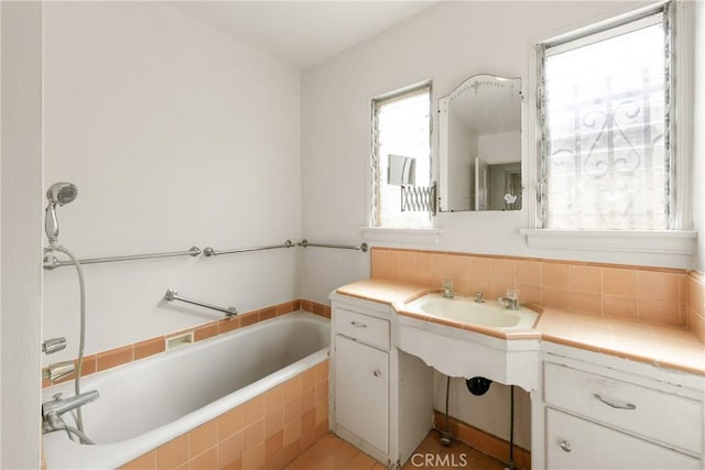 bathroom featuring sink, backsplash, and tiled tub